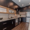 kitchen with large island and black cabinets and wood dloroing